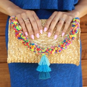 Straw clutch with blue tassel and pompoms